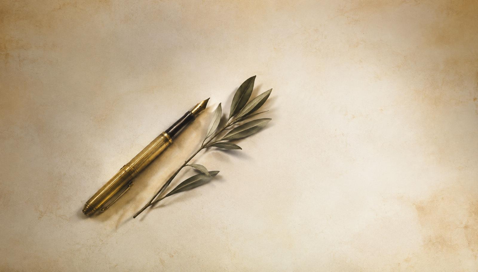 Antique gold fountain pen and olive sprig on parchment